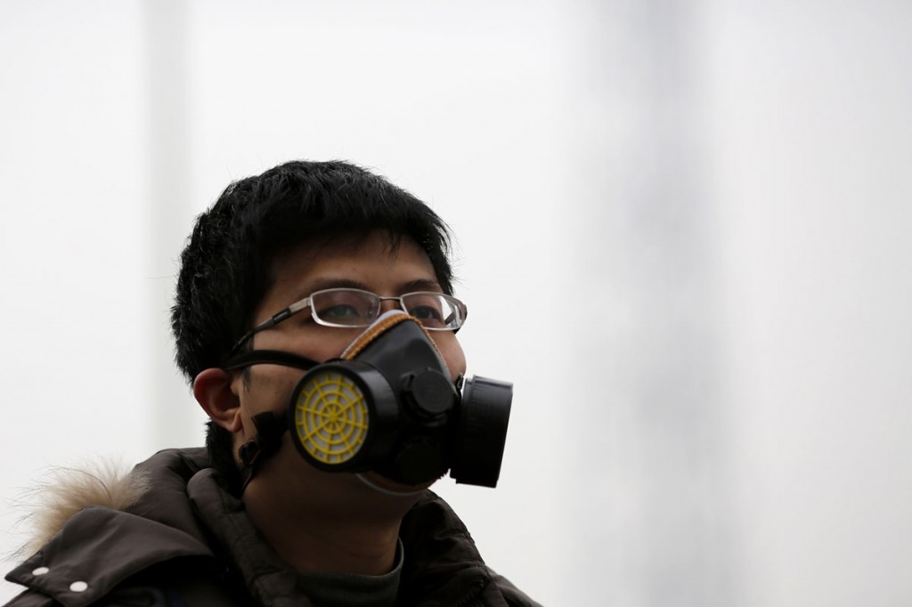 A man wearing a mask makes his way amid the heavy haze in Beijing